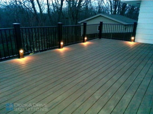 Side mount railing lights in the evening on a composite deck