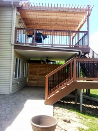 walkout deck with cedar pergola, stamped concrete patio below and privacy cedar wall