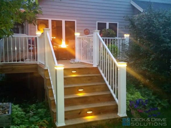treated deck stairs with stair riser lights and white railing