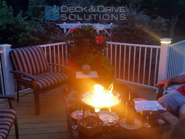 gas fire pit on deck with white railing