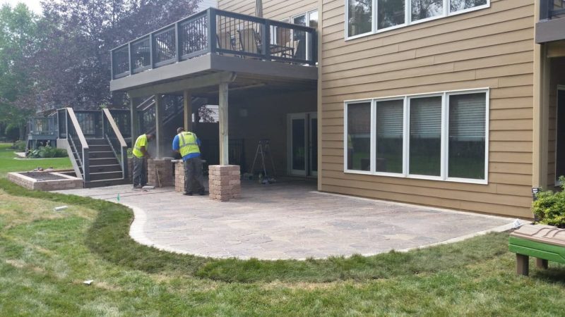 Landscapers at Work installing a paver patio under a walkout deck