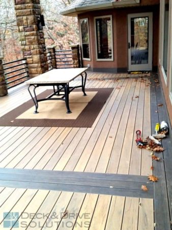 Table on rug in center of composite deck pictured framed with Mocha Decking