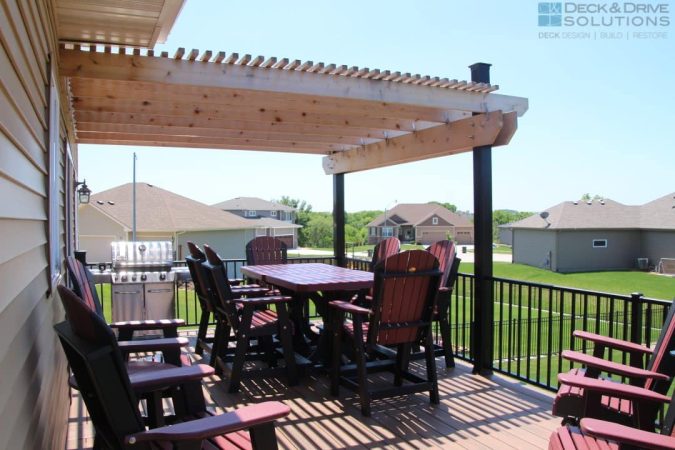 cedar pergola over a table and chairs overlooking backyard on a composite deck