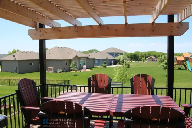 cedar pergola over a table and chairs overlooking backyard