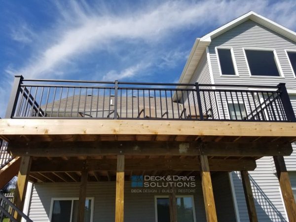 Metal railing on a walkout cedar deck with blue sky