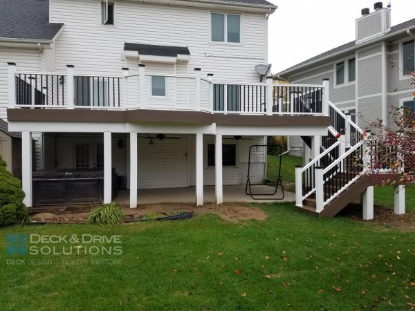 Walkout deck with white footing post and beams, white and black composite railing, timbertech composite decking