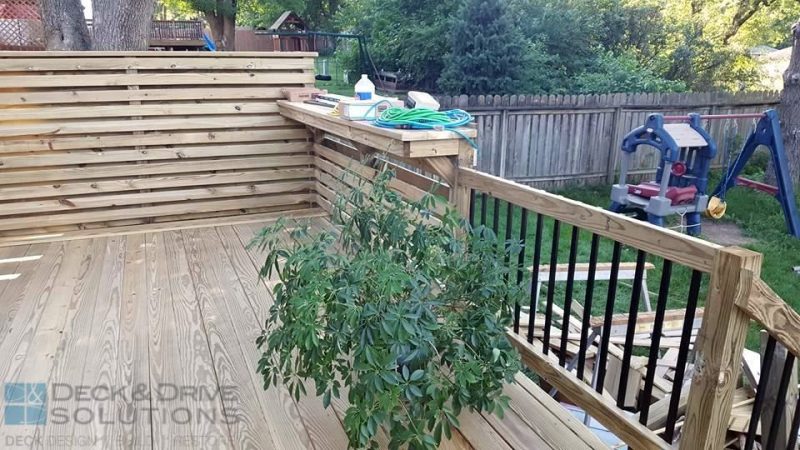 deck plant near custom bar rail and privacy wall on this treated deck