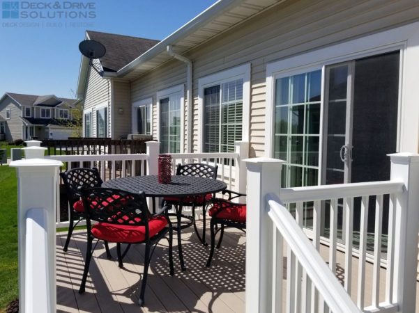 white composite railing with sandy birch decking on a deck with wrought iron table and chairs with red cushions