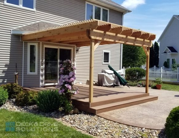 Cedar pergola on a composite platform deck with wrap around stairs with stamped concrete