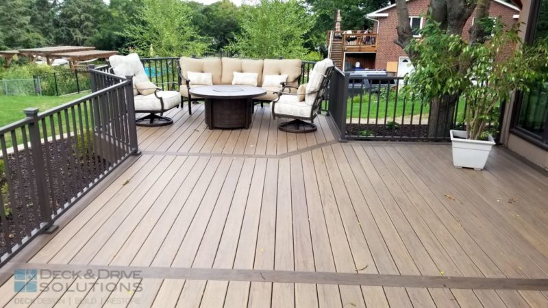 Timbertech composite accent board in mocha and main decking in pecan with octagon sitting area including fire pit and comfortable outdoor chairs