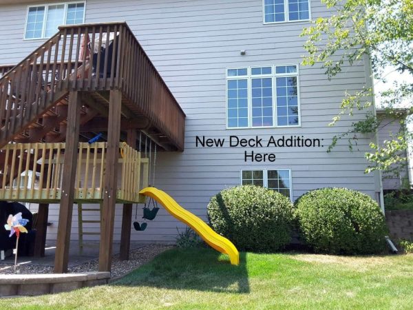 Old treated deck with playset and slide below