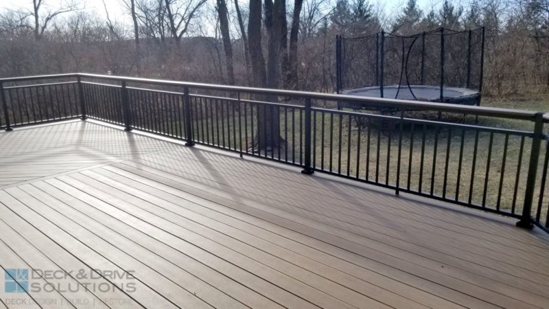 composite deck with upgraded railing in a wooded backyard