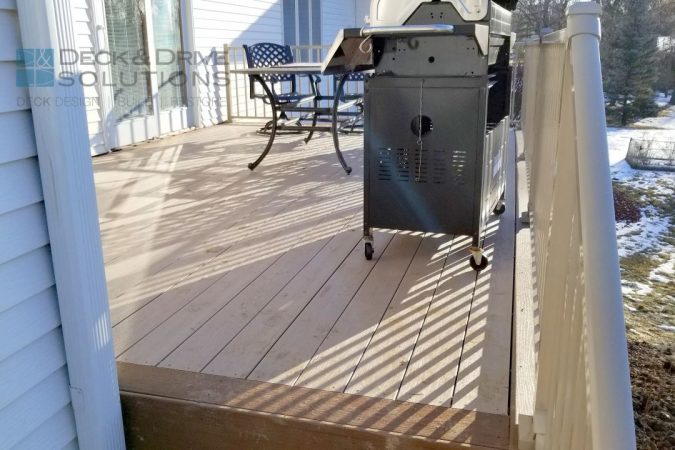 Picture frame brown oak with sandy birch main decking, grill on top with chairs in background
