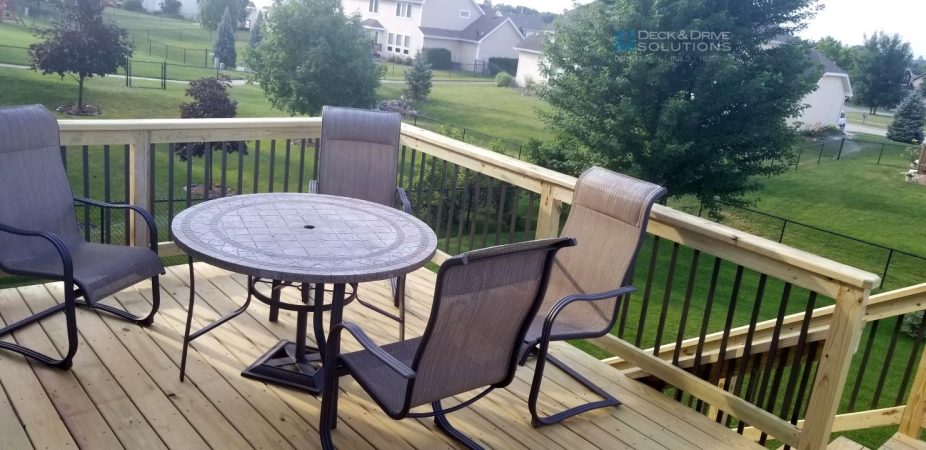 outdoor table and chairs in backyard on a deck