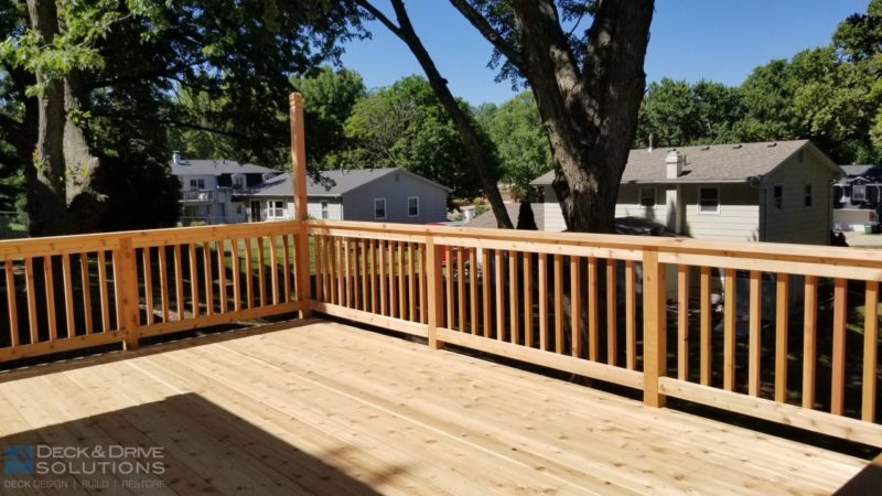 New deck with cedar post rail and cedar spindles, tall pole is for future lighting