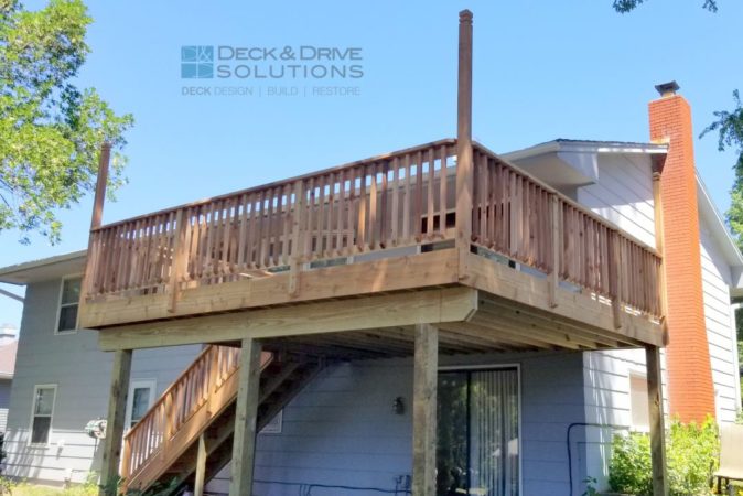 walkout deck with cedar post rail and cedar spindles, tall pole is for future lighting