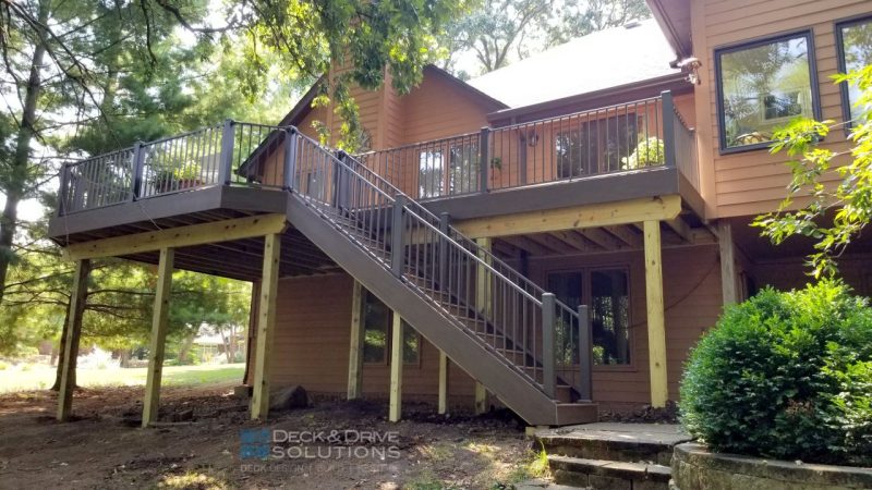Large Walkout deck with Timbertech Pecan and Mocha decking and bronze railing on a tan/brown house
