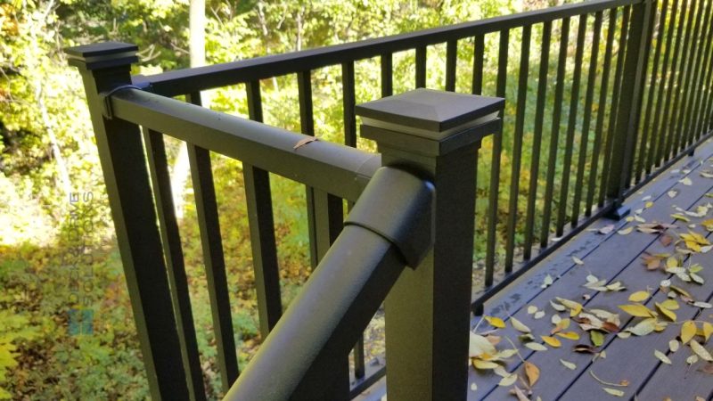 Metal Railing with post cap light with greenery in back