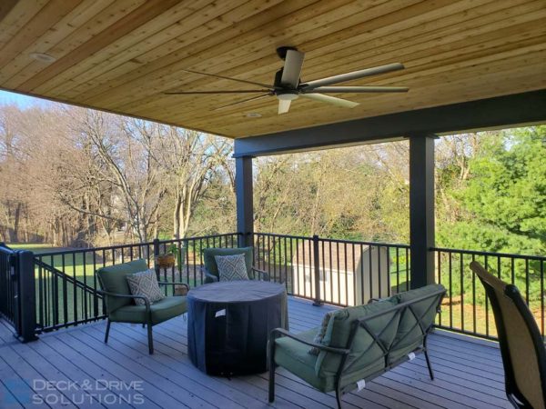 cedar ceiling with ceiling fan under a lean to roof with a composite deck, outdoor furniture set with fire pit and seating