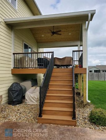 trex deck stairs with aluminum railing, stamped concrete, covered deck porch roof with cedar ceiling