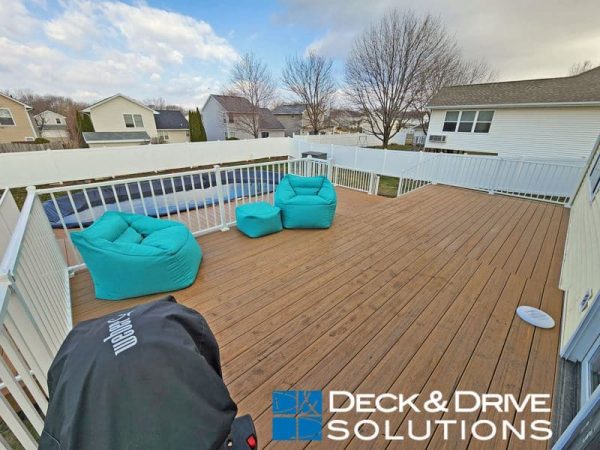 Timbertech Antique Leather decking with white railing and green chairs next to a pool deck