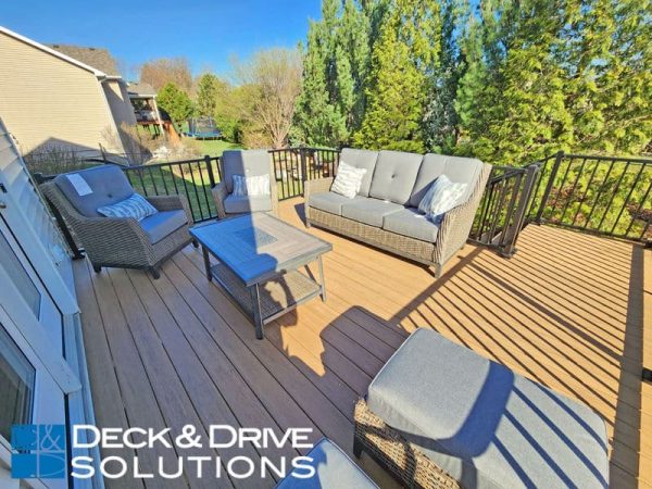 New outdoor furniture on new composite deck in Spring with trees behind