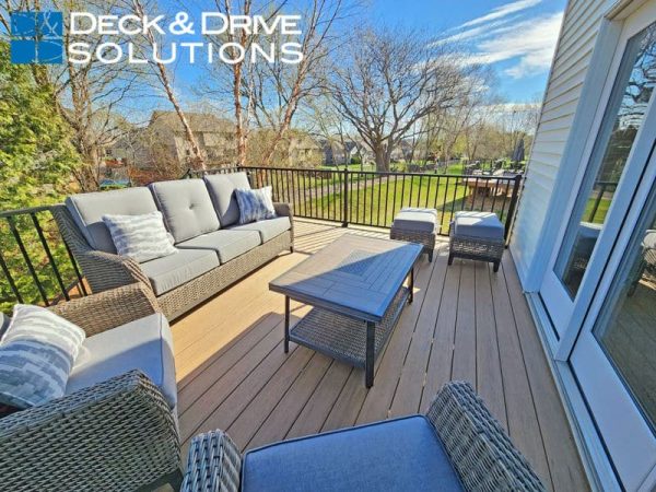 New outdoor furniture on new composite deck in Spring with trees behind