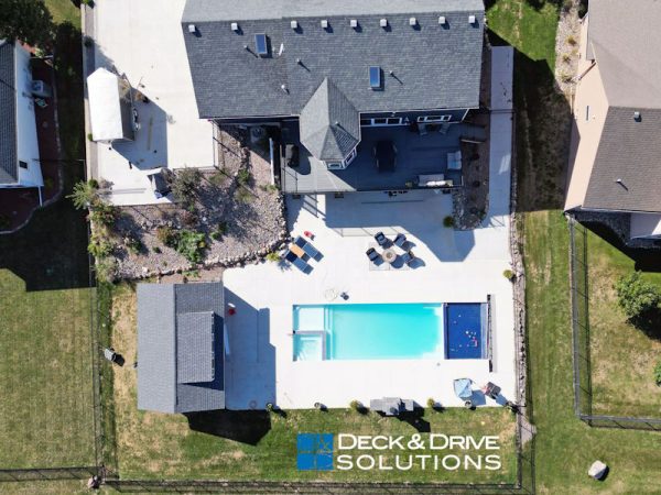 large composite deck and backyard pool behind house