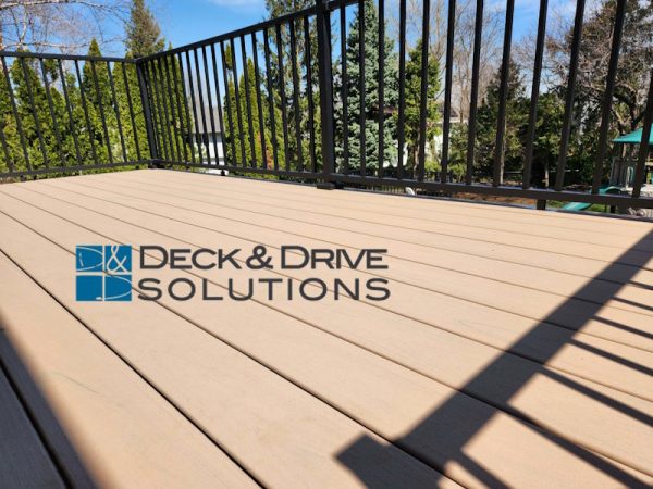 close view of Composite Decking of Trex Lineage series in carmel color with black railing behind