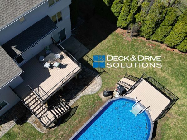 Overview of a backyard with new Trex deck and Trex pool deck around an above ground pool